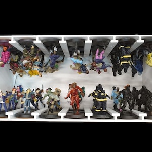 May include: A white display case filled with miniature figurines. The figurines are of various characters, including zombies, firefighters, and other figures. The figurines are painted in a variety of colors and are arranged on black bases.