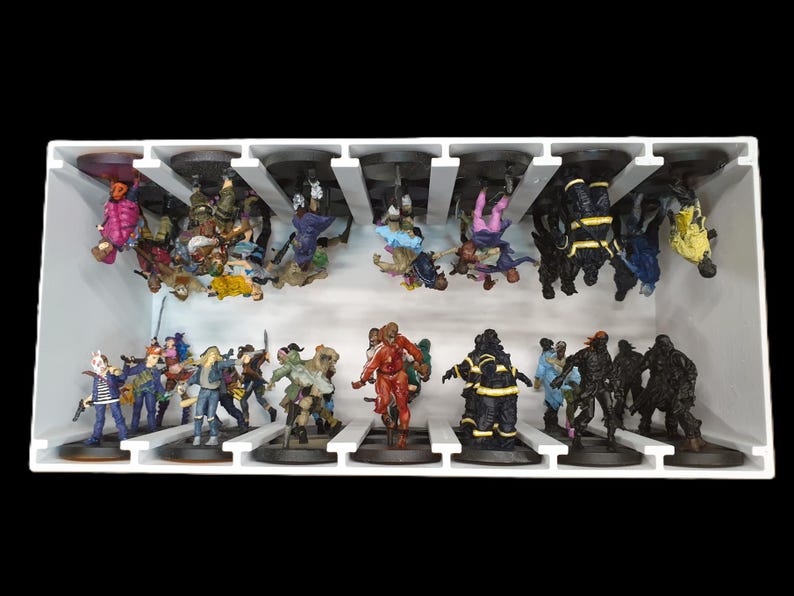 May include: A white display case filled with miniature figurines. The figurines are of various characters, including zombies, firefighters, and other figures. The figurines are painted in a variety of colors and are arranged on black bases.