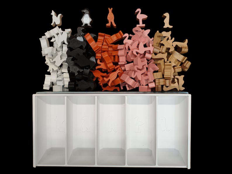 May include: A white wooden storage box with five compartments for organizing small items. The box is filled with colorful wooden animal figurines, including penguins, kangaroos, flamingos, and deer.