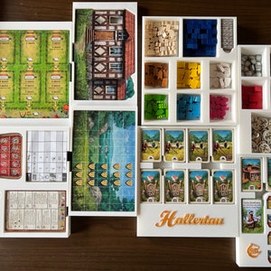 May include: White organizer with compartments for storing game pieces and cards. The organizer has a label that says "Hallertau".
