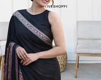 May include: A black saree with a decorative border featuring red, white, and gray patterns. The saree is draped over the shoulder and across the body. The image includes the text "TIVESHOPFI".