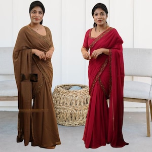 Puede incluir: Dos mujeres vistiendo saris, uno marrón y otro rojo, con adornos dorados. Los saris están drapeados en un estilo tradicional.