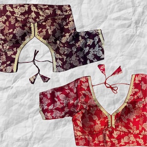 Könnte beinhalten: Zwei bestickte Blusen mit Blumenmustern. Die Bluse oben ist weinrot mit goldener Stickerei. Die Bluse unten ist rot mit goldener Stickerei.