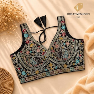 Puede incluir: Una blusa negra sin mangas con intrincados bordados florales y de cachemira en tonos azul, rosa y amarillo. La prenda presenta un escote en V profundo, un corpiño estructurado y lazos de tela negra en la parte posterior del cuello.