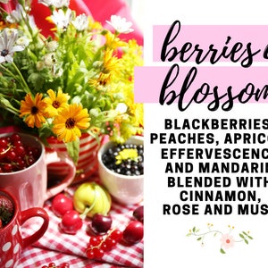 May include: A red and white checkered tablecloth with two red mugs filled with berries, a bowl of blackberries, and a green apple. The background features a bouquet of yellow and white flowers and the text "berries & blossoms BLACKBERRIES, PEACHES, APRICOT, EFFERVESCENCE AND MANDARIN BLENDED WITH CINNAMON, ROSE AND MUSK"