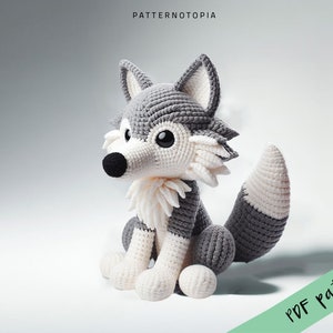 May include: A crocheted gray and white wolf plush toy sitting on a white surface. The wolf has a black nose and large black eyes. The text "PDF pattern" is in the lower right corner of the image.