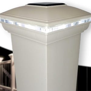 May include: A white square post cap with a solar powered LED light. The light is embedded in the top of the cap and has a clear acrylic trim around the edge.