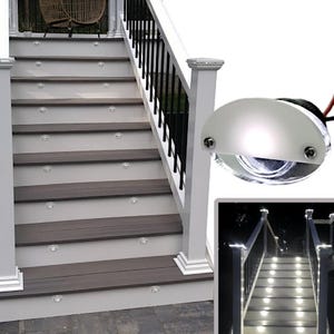Puede incluir: Un conjunto de luces LED blancas para escalones ilumina un tramo de escaleras con una barandilla negra. Las luces están empotradas en los escalones y emiten un brillo cálido. Las luces también se muestran en primer plano, destacando su diseño y funcionalidad.