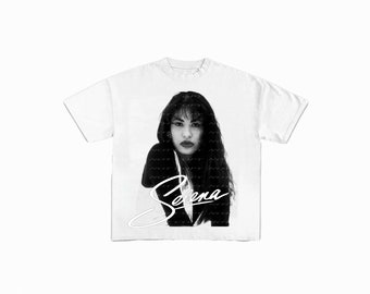 Könnte beinhalten: Weißes T-Shirt mit einem Schwarzweißbild von Selena Quintanilla, darunter ihre Unterschrift in Weiß.