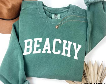 May include: A light green sweatshirt with the word "Beachy" printed in white on the front.