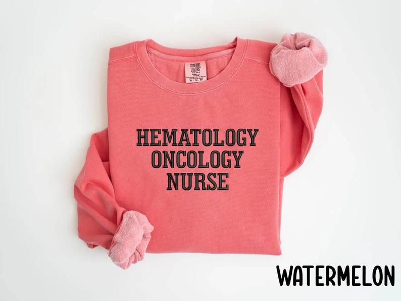 May include: A pink sweatshirt with the text "Hematology Oncology Nurse" in black.