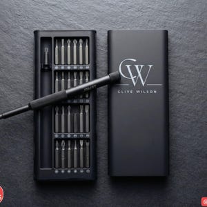 May include: A black precision screwdriver set featuring a handle and multiple interchangeable bits stored in a rectangular case. The case lid is marked with the monogram CW and the name CLIVE WILSON in white text, with JOREST on the handle.