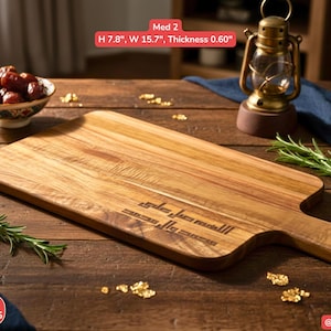 May include: A rectangular wooden cutting board with a handle, measuring 7.8 inches in height and 15.7 inches in width. The board has engraved text and is surrounded by decorative elements, including a small bowl of dates and a vintage lantern.