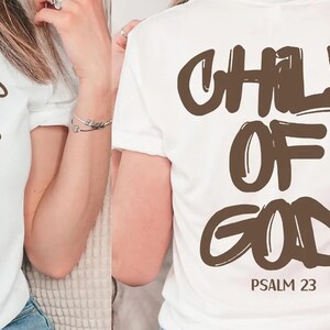 two people wearing white t-shirts with the text "CHILD OF GOD" printed on the back.