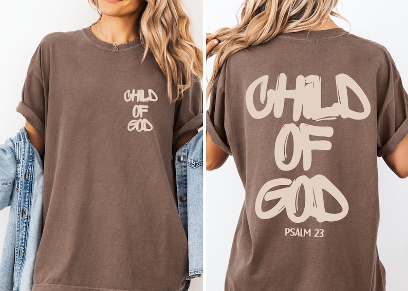a woman wearing a brown t-shirt with the text "CHILD OF GOD" printed on it.