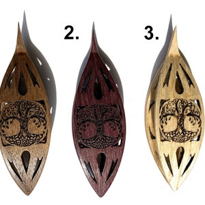 Pode incluir: Três tigelas de lã de madeira, cada uma com uma mancha de madeira diferente. As tigelas têm a forma de uma lágrima e apresentam um design de árvore da vida esculpido. As tigelas são etiquetadas com 1, 2 e 3.
