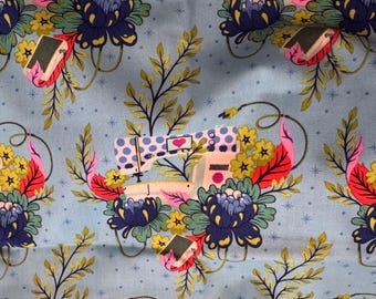May include: A light blue fabric featuring a repeating pattern of sewing machines with blue polka-dot tops, pink hearts, and large dark blue flowers. The design includes green leafy branches, small yellow flowers, and bright pink leaves on a dotted background.