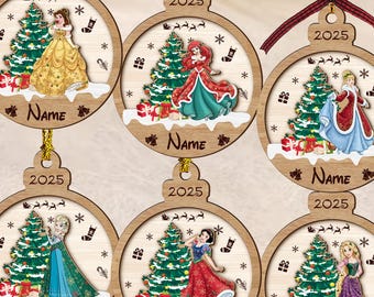 Puede incluir: Adornos navideños de madera con princesas de Disney. Cada adorno circular muestra una princesa, un árbol de Navidad, regalos, copos de nieve y el año 2025. La palabra "Name" también está incluida.