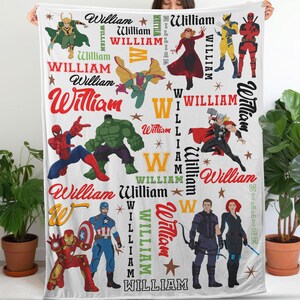 May include: White blanket featuring various superhero illustrations and the name "William" in multiple fonts and colors. The blanket includes images of characters like Spider-Man, Hulk, and Captain America, with star accents.