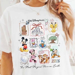 Puede incluir: Camiseta blanca con un colorido gr&aacute;fico de Disney World. El dise&ntilde;o incluye varios personajes y lugares emblem&aacute;ticos de Disney, con el texto "Walt Disney World", "The Most Magical Place on Earth" y el a&ntilde;o "2026".