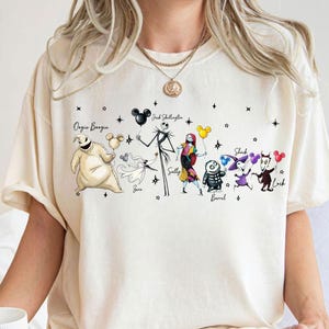 K&ouml;nnte beinhalten: Eine wei&szlig;e Keramik-Tasse mit schwarzem Henkel und dem Text "But First, Coffee" in fetter, schwarzer Schrift. Die Tasse steht vor einem verschwommenen Hintergrund. Die Tasse ist etwa 10 cm hoch.