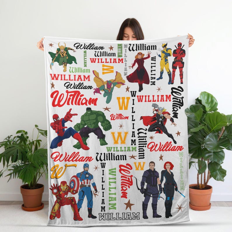 May include: White blanket featuring various superhero illustrations and the name "William" in multiple fonts and colors. The blanket includes images of characters like Spider-Man, Hulk, and Captain America, with star accents.