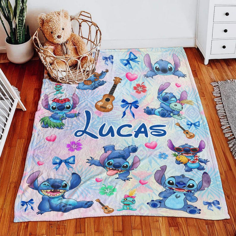 Op de afbeelding: Een gepersonaliseerde deken met het personage Stitch uit Lilo & Stitch. De deken heeft een pastelkleurige achtergrond met Stitch-illustraties, ukeleles, strikken en de naam "Lucas" in blauw schrift. De deken is voor een kind.