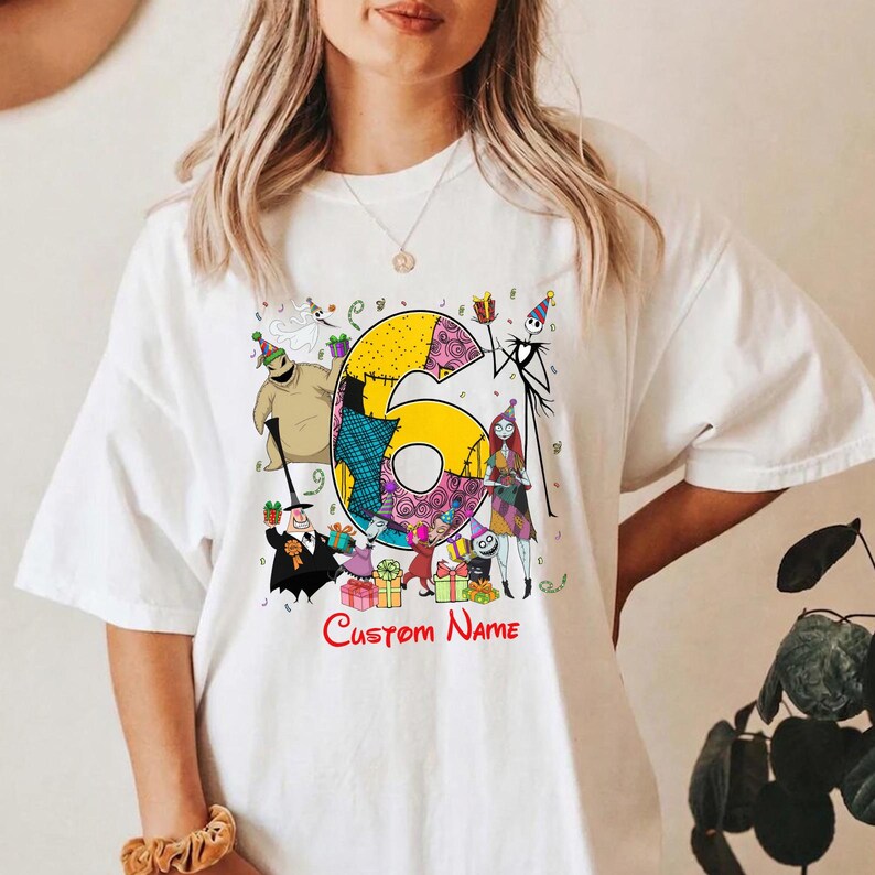 May include: A white t-shirt featuring a large yellow number six decorated with patchwork patterns. The design includes various animated characters from The Nightmare Before Christmas, colorful gift boxes, and the red text Custom Name.