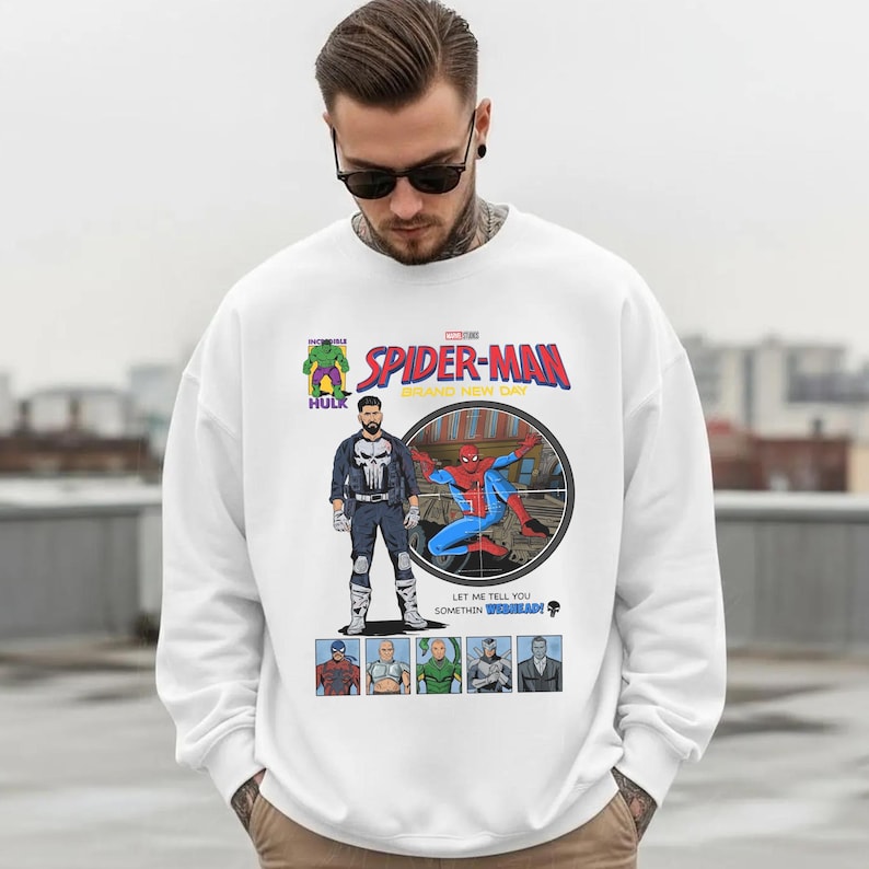 May include: White sweatshirt featuring a comic book-style graphic of Spider-Man, The Punisher, and Hulk. The graphic includes the text "SPIDER-MAN BRAND NEW DAY" and other comic book elements. The sweatshirt is a crew neck style.