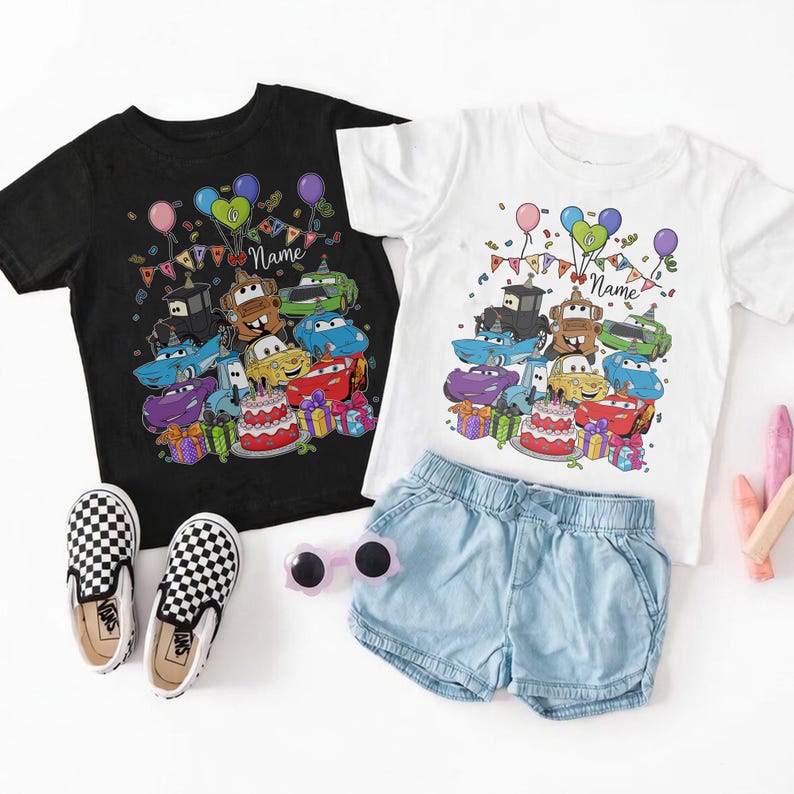 Peut inclure: Des baskets Vans noires et blanches &agrave; enfiler &agrave; c&ocirc;t&eacute; d'un t-shirt noir et d'un t-shirt blanc. Les chemises pr&eacute;sentent un graphisme color&eacute; de voitures de dessins anim&eacute;s, de ballons et d'un g&acirc;teau d'anniversaire. Un short en jean bleu clair et des lunettes de soleil roses sont &eacute;galement dans l'image.