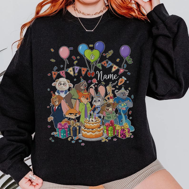 Puede incluir: Sudadera negra con un dise&ntilde;o de cumplea&ntilde;os con personajes de dibujos animados, globos y una tarta. El dise&ntilde;o incluye la palabra "Name" y cajas de regalo. El tema general es una celebraci&oacute;n de cumplea&ntilde;os.