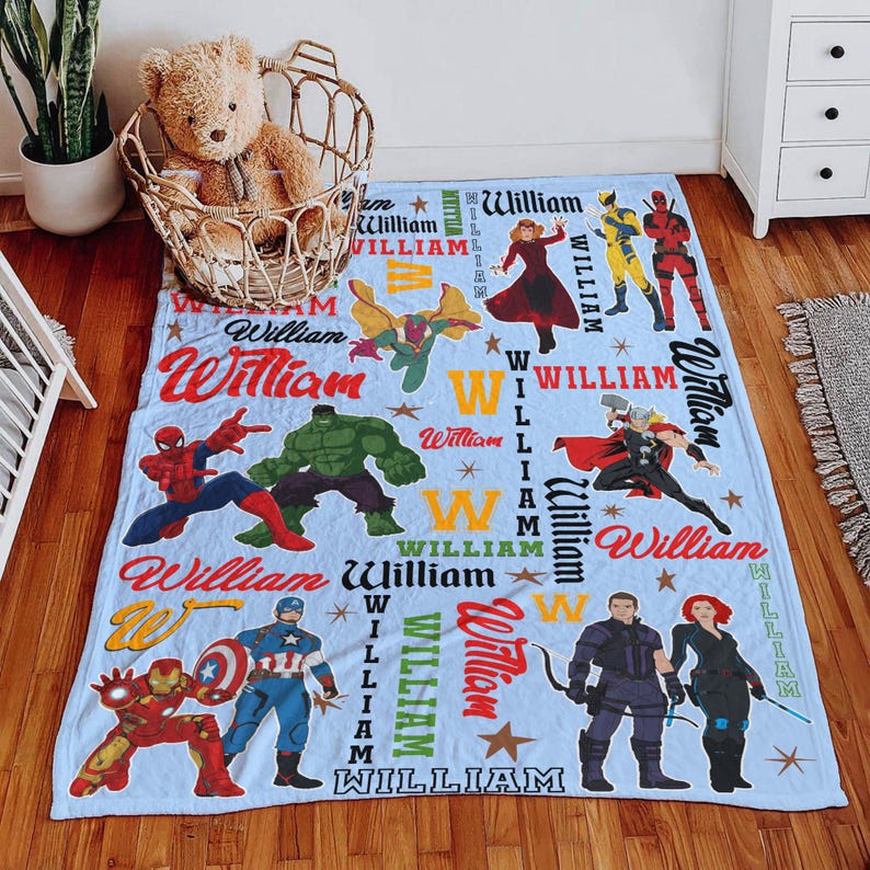 May include: A light blue blanket featuring various Marvel superhero characters, including Spider-Man, Hulk, and Captain America. The blanket has the name "William" printed in multiple locations, along with stars and the letter "W".