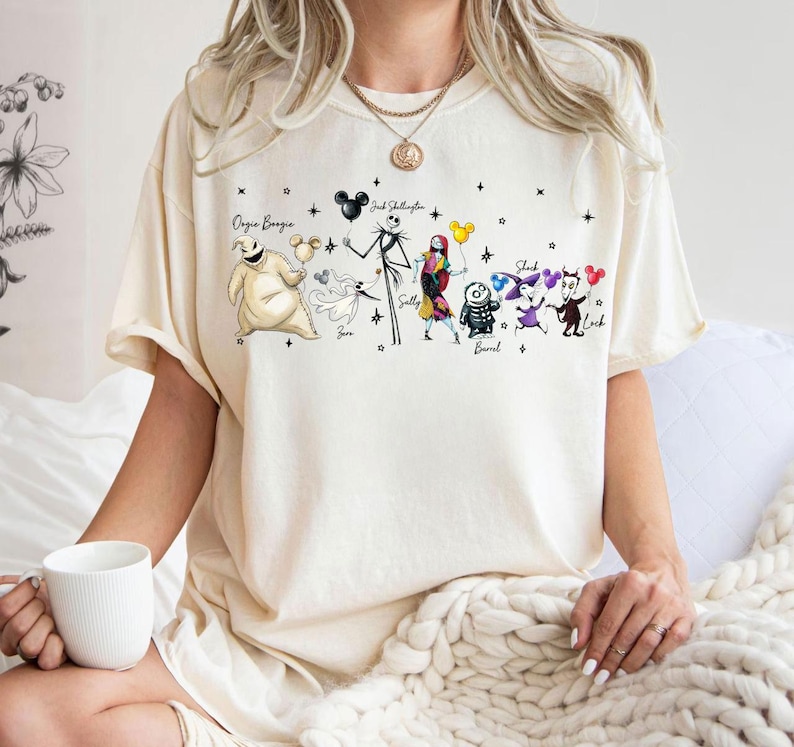 K&ouml;nnte beinhalten: Eine wei&szlig;e Keramik-Tasse mit schwarzem Henkel und dem Text "But First, Coffee" in fetter, schwarzer Schrift. Die Tasse steht vor einem verschwommenen Hintergrund. Die Tasse ist etwa 10 cm hoch.