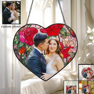 May include: A heart-shaped stained glass panel featuring a couple's photo, surrounded by red and pink roses. The panel is framed in black and hangs from a chain. The words "custom photo" are in the upper left corner.