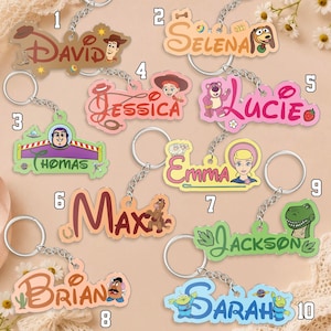 May include: Ten custom acrylic keychains featuring Toy Story character themes and personalized names including David, Selena, Jessica, Lucie, Thomas, Emma, Max, Brian, Jackson, and Sarah, each attached to a silver metal split ring keychain.
