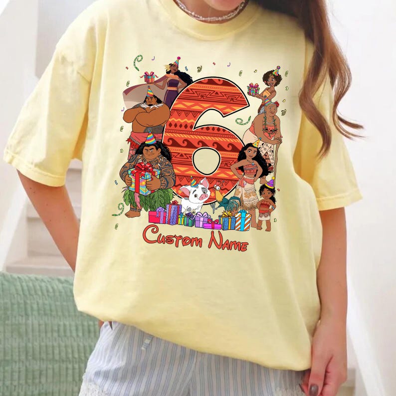 May include: A pale yellow t-shirt featuring a large orange patterned number six surrounded by various animated characters wearing party hats. The graphic includes colorful gift boxes, confetti, and the red text Custom Name below the design.