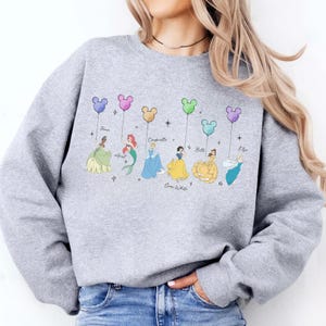 May include: A set of three ceramic mugs with a speckled, matte finish. The mugs are in shades of cream, light gray, and dark gray. Each mug has a simple, minimalist design and a rounded handle.