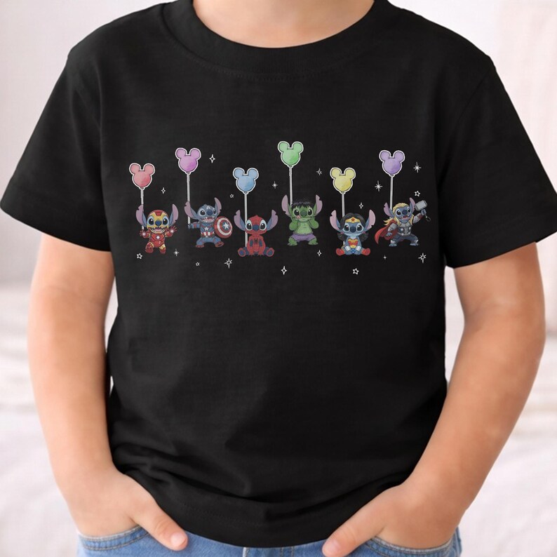 May include: Black t-shirt featuring a colorful graphic of Stitch characters dressed as superheroes, each holding a Mickey Mouse-shaped balloon. The characters include Iron Man, Captain America, Deadpool, Hulk, and Thor.