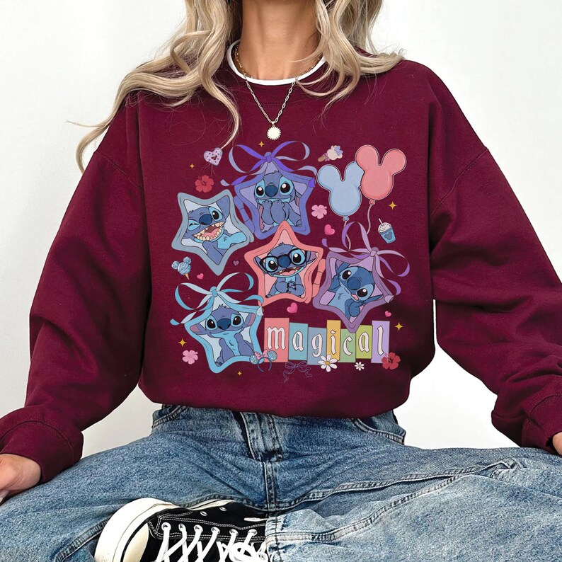 Może przedstawiać: Bordowa bluza z kolorową grafiką postaci Stitch w ramkach w kształcie gwiazd. Słowo "magical" jest wyświetlane pod postaciami. Projekt zawiera kwiaty, serca i balony.