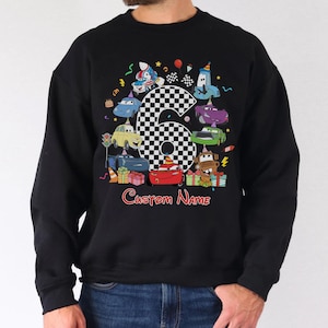 May include: Black sweatshirt with a colourful graphic of cartoon cars around a large number six with a chequered pattern. The words "Custom Name" are written in red script below. Birthday theme.