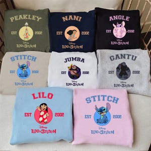 May include: Collection of Disney Lilo & Stitch sweatshirts in various colors, each featuring a different character name and image. Designs include Stitch, Lilo, Nani, and others, with the year 2002 and the Disney Lilo & Stitch logo.