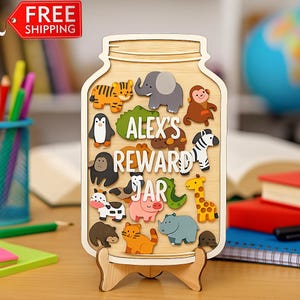 May include: Wooden reward jar with animal cutouts, including a tiger, elephant, monkey, zebra, and giraffe. The jar is engraved with the text "ALEX'S REWARD JAR". The jar is displayed on a wooden stand.