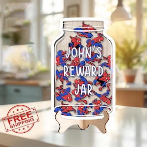Op de afbeelding: Houten beloningspot in de vorm van een weckpot, gevuld met Spider-Man-figuren. De pot heeft de tekst "JOHN'S REWARD JAR" in het wit. Het wordt weergegeven op een houten standaard.