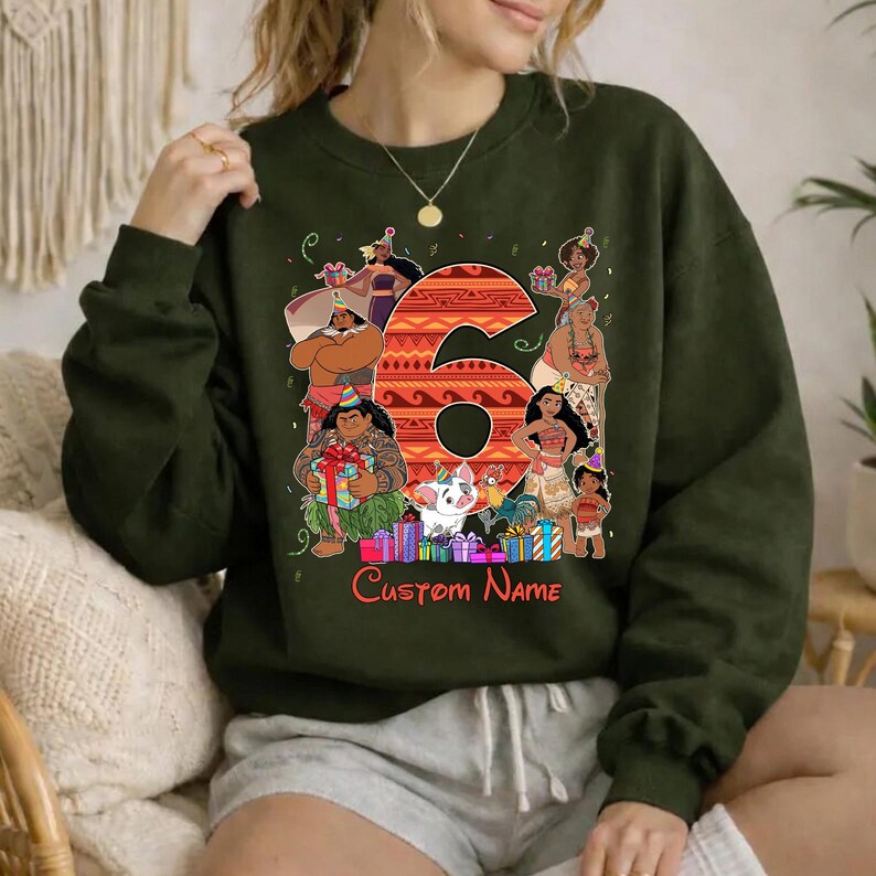 May include: A dark olive green crewneck sweatshirt featuring a large orange patterned number six surrounded by various animated characters wearing party hats, colorful gift boxes, and the red text Custom Name printed at the bottom center.