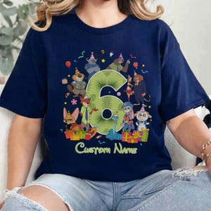 May include: A navy blue t-shirt featuring a large green number six surrounded by various cartoon animal characters wearing party hats. The design includes colorful gift boxes, confetti, and the text Custom Name printed in light green at the bottom.