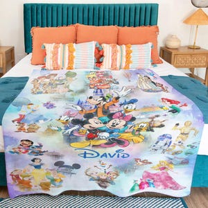 Op de afbeelding: Een kleurrijke deken met Disney-personages, waaronder Mickey Mouse, Minnie Mouse, Donald Duck en Goofy. De deken heeft de gepersonaliseerde naam "DAVID" en bevat afbeeldingen van prinsessen en andere personages.