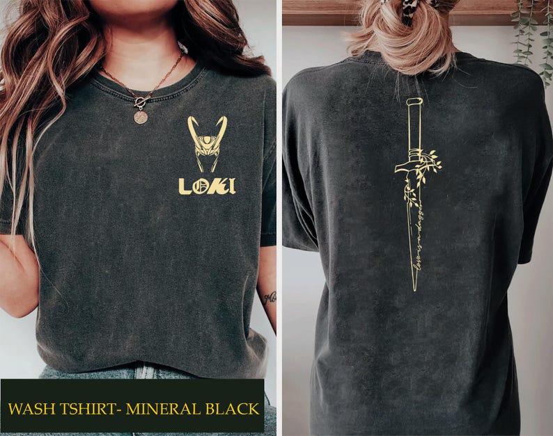 May include: Dark gray t-shirt with a gold Loki design on the front and a gold dagger illustration on the back. The front features the Loki helmet and the word "LOKI". The back has the text "Love is a dagger".