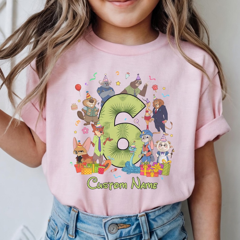 May include: A light pink t-shirt featuring a large green number six surrounded by various animated animal characters wearing party hats. The graphic includes colorful gift boxes, confetti, and the text Custom Name printed in green below the design.
