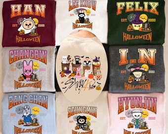 May include: A collection of Halloween-themed sweatshirts featuring cartoon characters and the text "HAN", "LEE KNOW", "FELIX", "CHANGBIN", "I.N", "HYUNJIN", "BANG CHAN", and "SEUNGMIN". Each sweatshirt has a unique design with pumpkins, tombstones, and the word "HALLOWEEN".