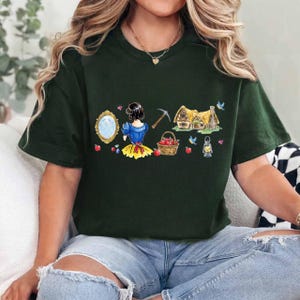 Peut inclure: Une tasse en c&eacute;ramique blanche avec une anse noire et le texte "But First, Coffee" en noir, dans une police manuscrite. La tasse est pos&eacute;e sur une surface blanche.